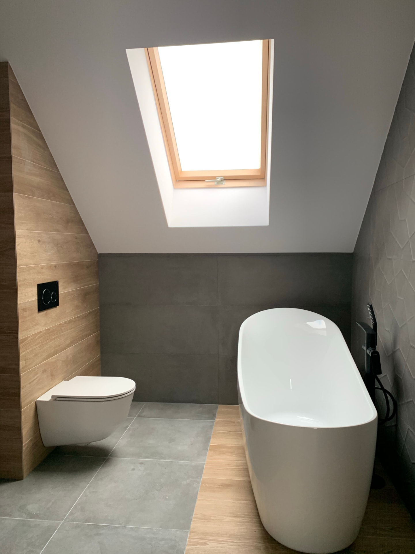 Modern saniertes Badezimmer im Dachgeschoss mit freistehender Badewanne